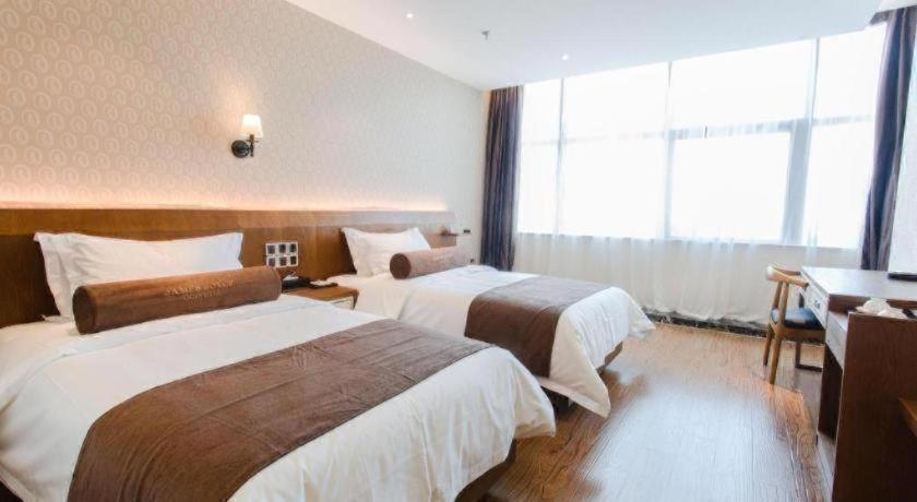 een hotelkamer met twee bedden en een groot raam bij James Joyce Coffetel Wuhu Wanzhi High-Speed Railway Station in Liangzhongchang