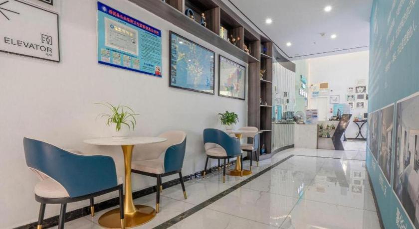 a restaurant with two tables and chairs in a room at Xana Lite Anqing Yuexi Swan Squre Branch in Yuexi