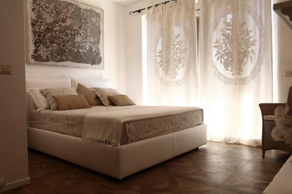 ein weißes Schlafzimmer mit einem Bett und einem Fenster in der Unterkunft Casa Fioravanti in Albinia