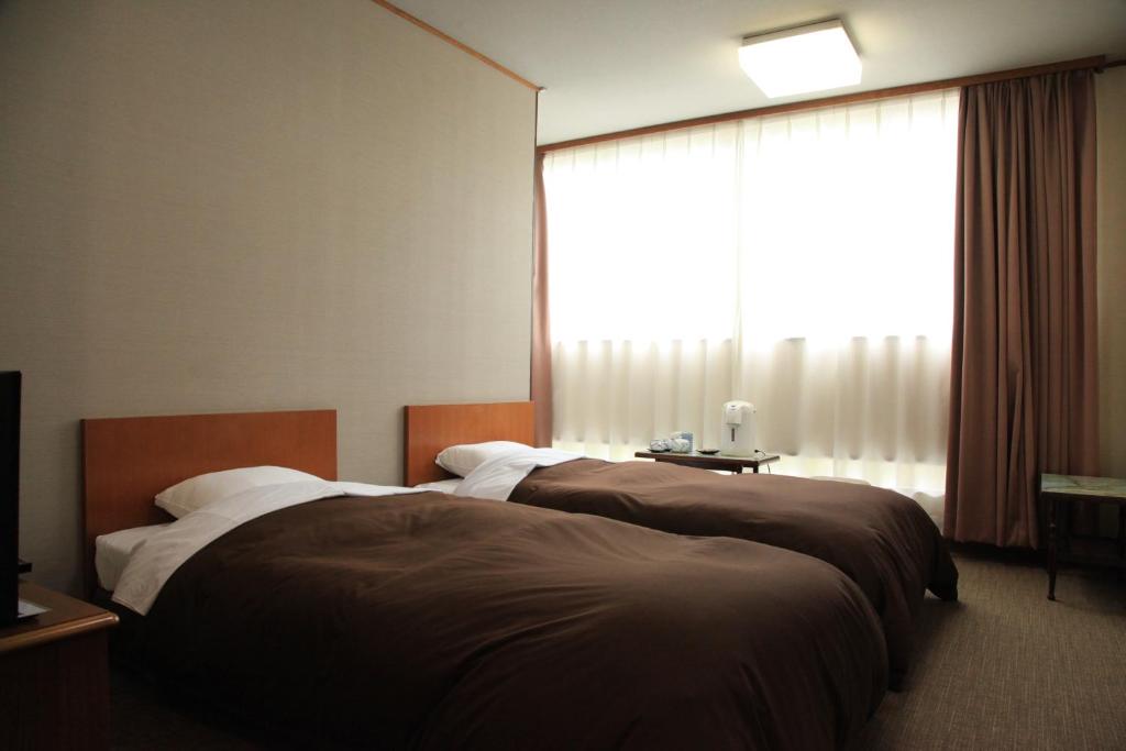 Postel nebo postele na pokoji v ubytování Hotel New Kotobuki