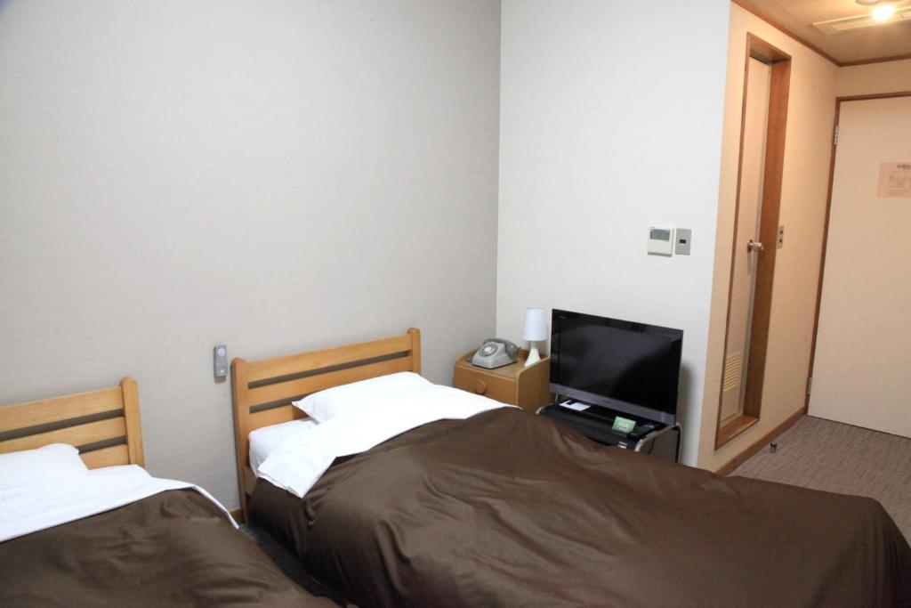 Postel nebo postele na pokoji v ubytování Hotel New Kotobuki