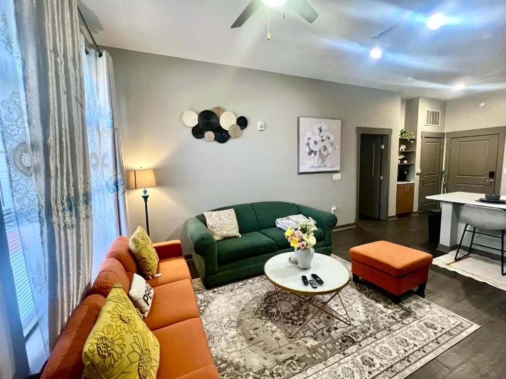 a living room with a green couch and a table at Uptown Charlotte Modern Stay 2BR in Charlotte