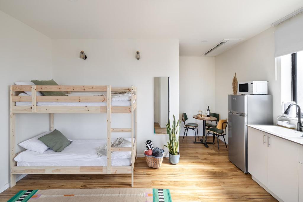 a room with two bunk beds and a kitchen at מעגל השמש in Poriyya Illit