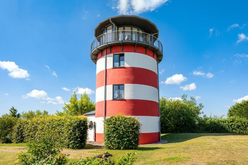 a red and white lighthouse with a balcony on it at Ferienhaus Leuchty in Hohenkirchen