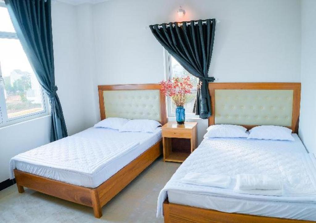 a bedroom with two beds and a window at Hong Ha Hotel in Pleiku Airport