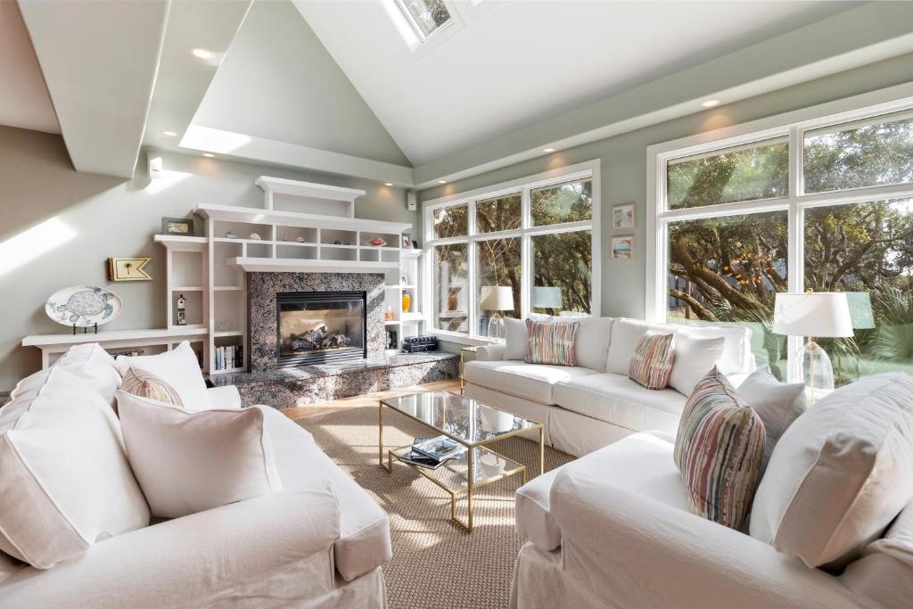 a living room with white furniture and a fireplace at SS52: 52 Surfsong in Kiawah Island