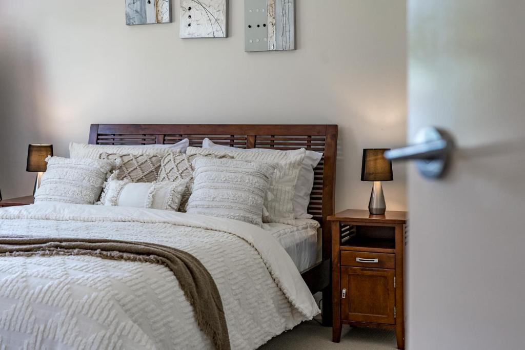 维克多港K Rose Cottage In the heart of Victor Harbor - No Linen Included的一间卧室配有一张床和一个带两盏灯的床头柜。