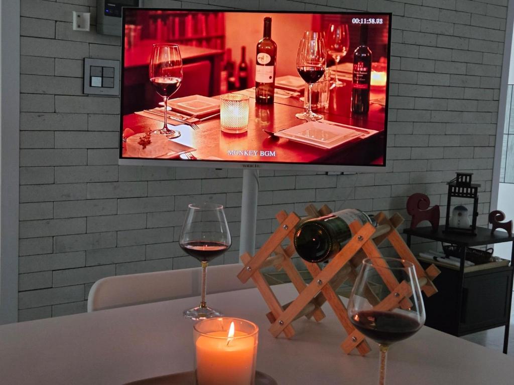 une table avec deux verres de vin et une bougie dans l'établissement 달빛그리기Moonlight, à Daegu