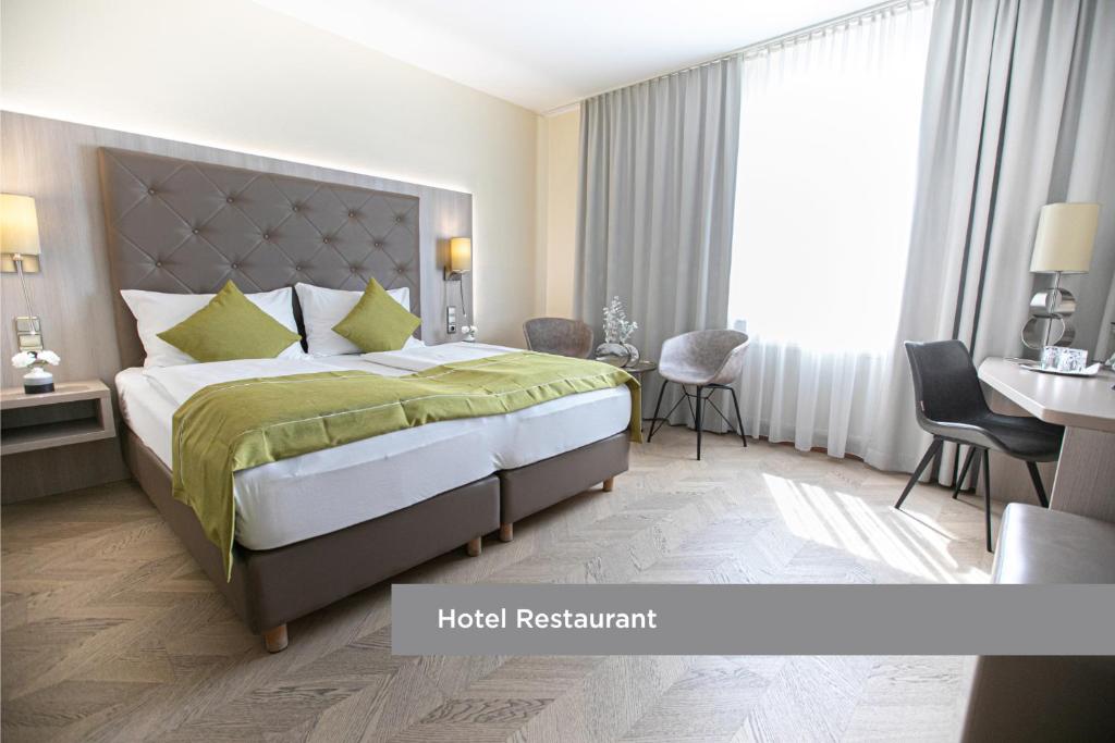 a hotel room with a bed and a desk at Das Reinisch Hotel - near Vienna Airport in Schwechat