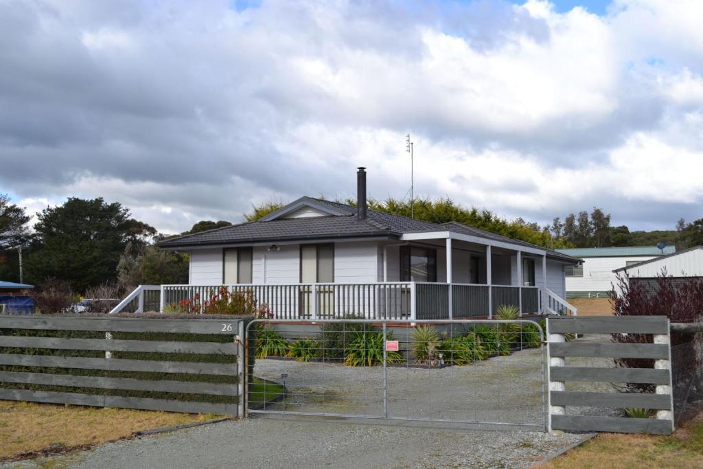a white house with a fence in front of it at Shelby s Lodge in Evergreen