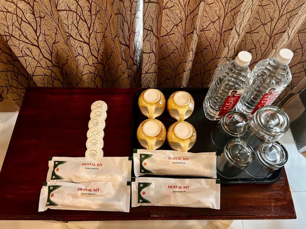 a table with bottles of water and a tray with spoons at Luxus Resort in Puducherry