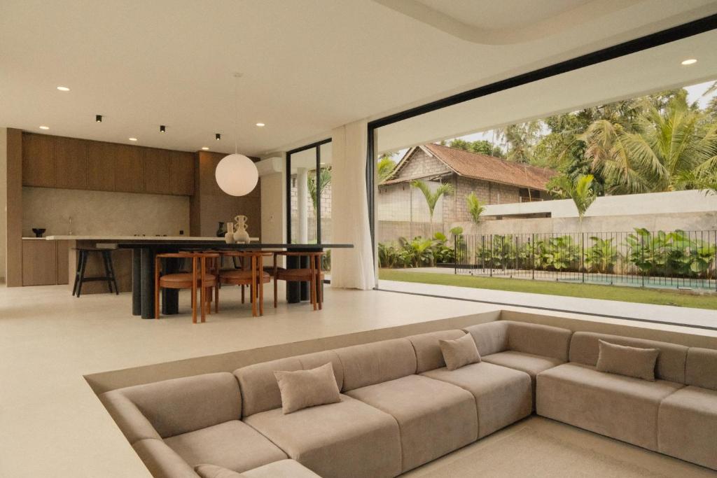 an open living room with a couch and a table at Prana Ubud in Tegalalang