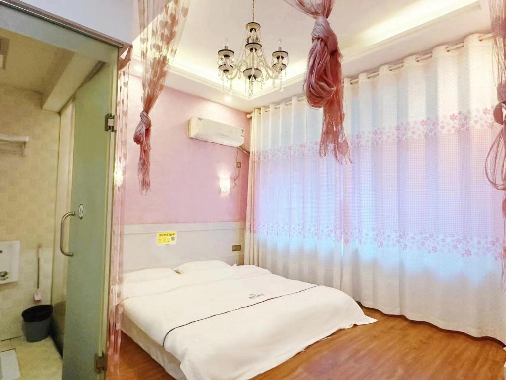 a bedroom with a bed and a chandelier at The Cozy Nook in Zhangjiajie