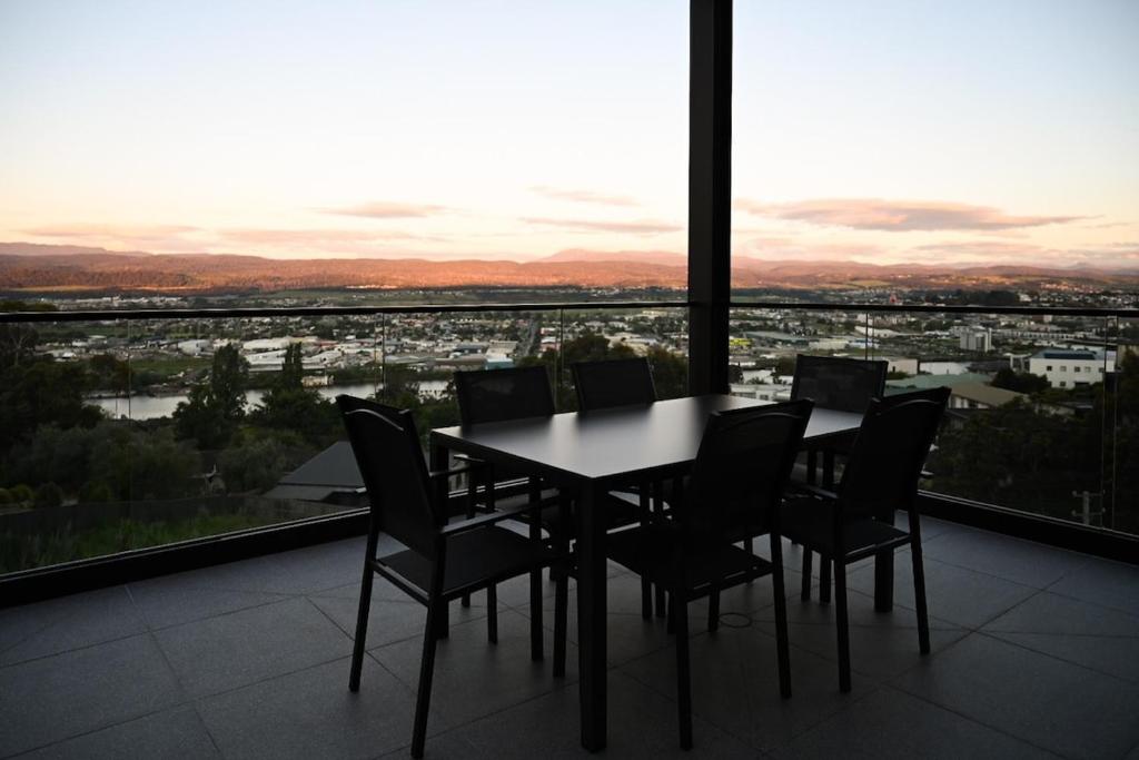 una mesa y sillas en una habitación con vistas en Tamar Views, en Inveresk