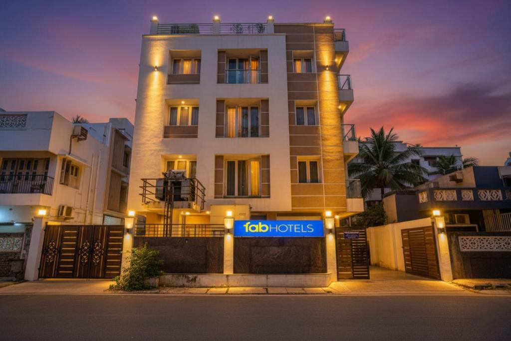 a building with a hotel sign in front of it at FabHotel Home Tree Service Apartment - Nr Anna Tower in Chennai
