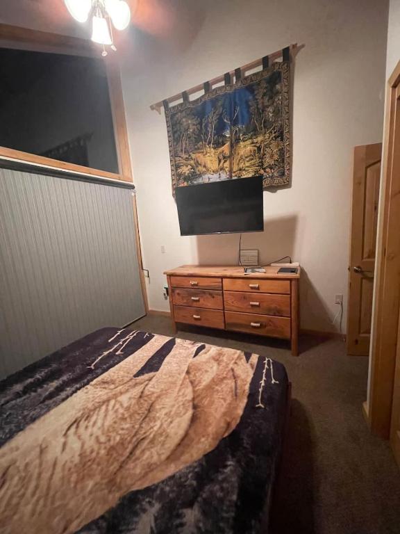a bedroom with a bed and a tv on the wall at Mountainside Family Chalet in Yosemite West