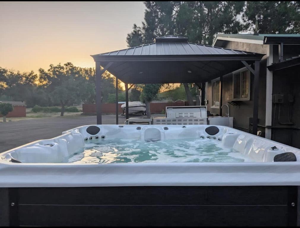 a hot tub in a yard with an umbrella at Modern Cabin Bungalow in Mariposa