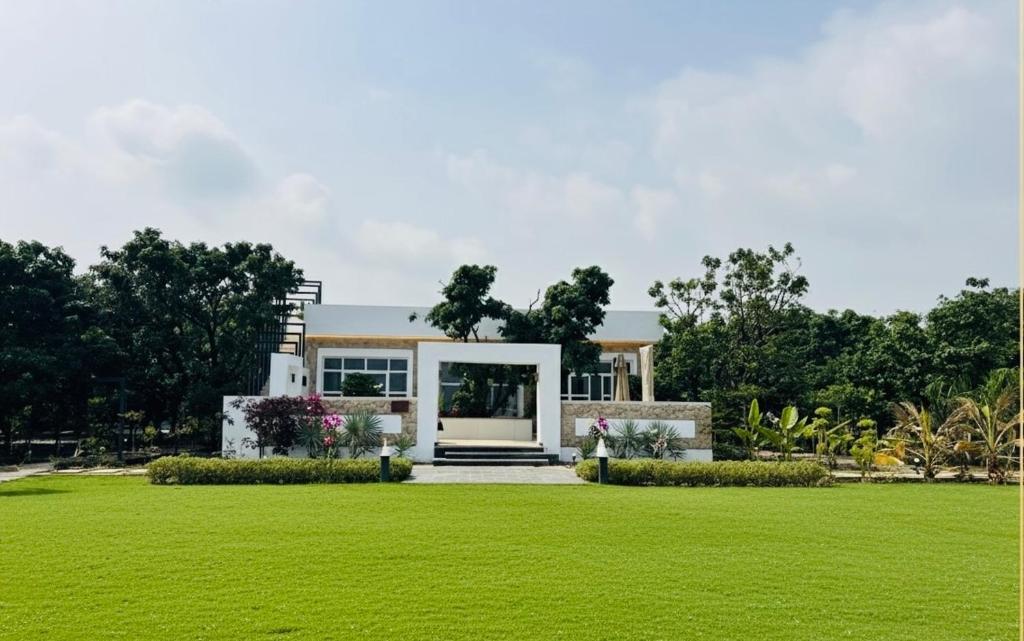 a house with a green lawn in front of it at Privé Residence in Rāmnagar