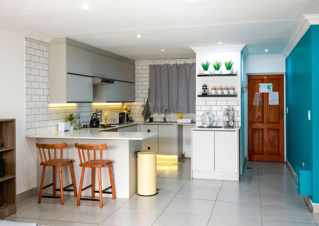 a kitchen with a counter and two bar stools at Neptunes Hideaway in Jeffreys Bay