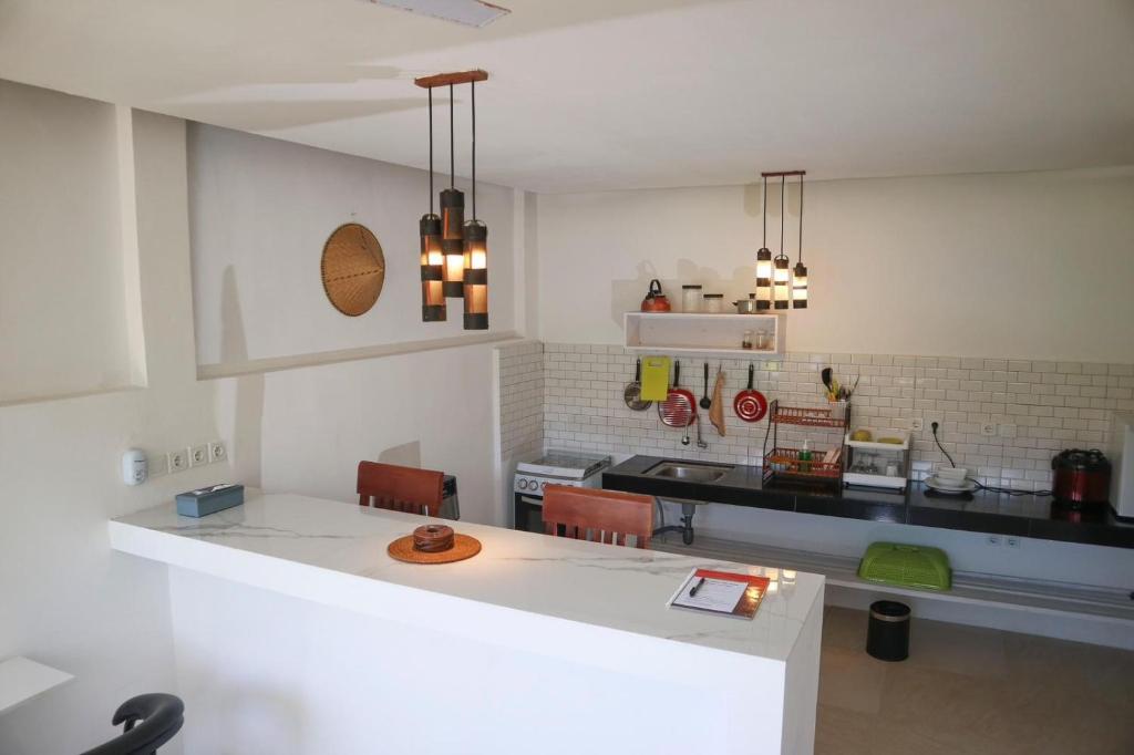 a kitchen with a counter with chairs and a table at bali amed feel home in Amed