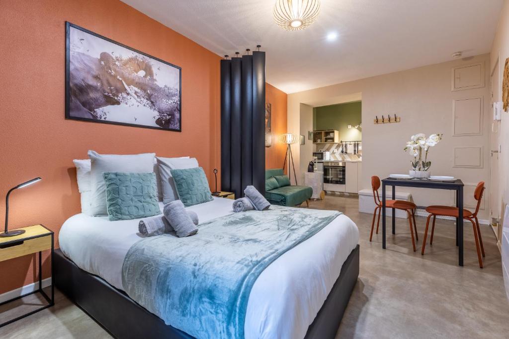 a bedroom with a large bed and a living room at L'éléhouse Studio Terrasse à RIOM in Riom