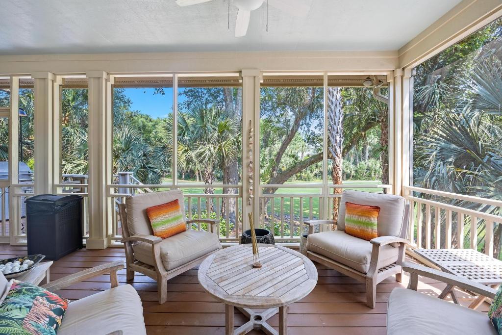 a screened in porch with chairs and a table at OG23: 23 Ocean Green in Kiawah Island