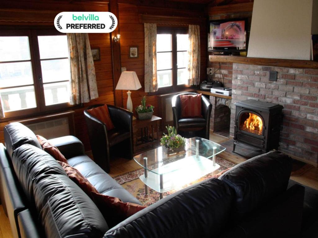 Una sala de estar con un sofá y una chimenea. en Longfaye Chalet with Sauna, en Longfaye