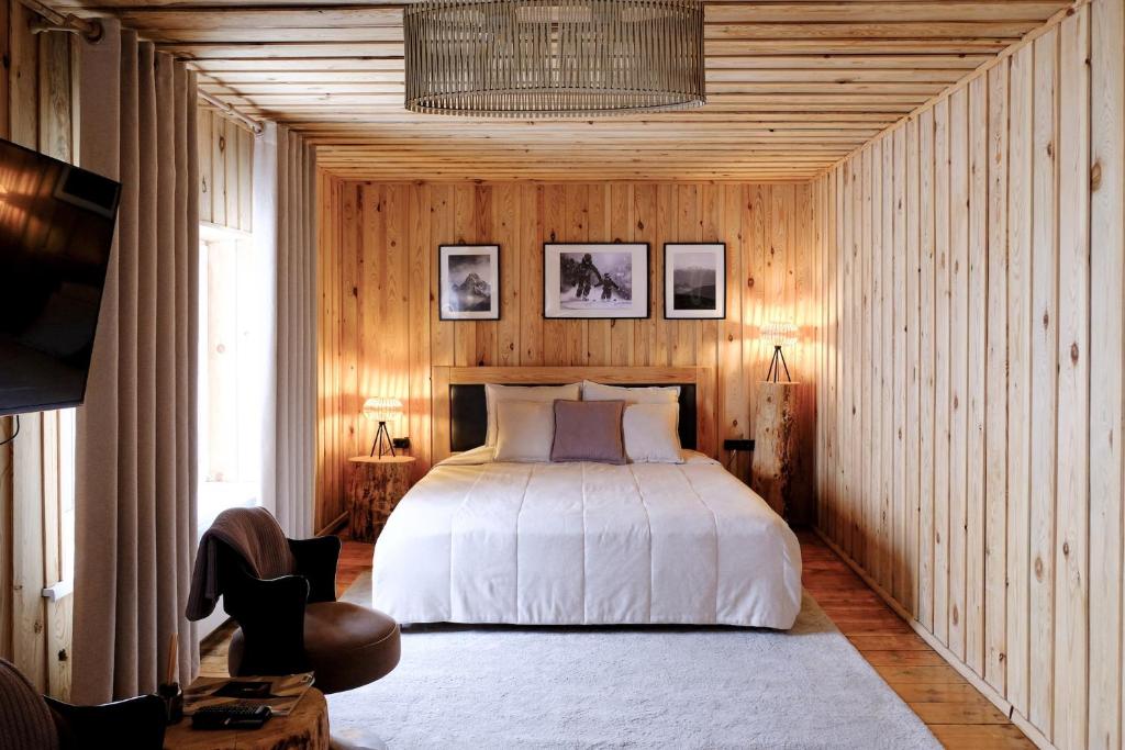 a bedroom with a bed in a wooden wall at Le Mont in Almaty