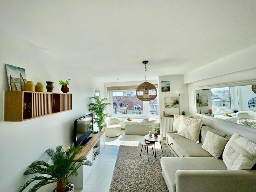 a living room with a couch and a tv at BEACH apartment met directe toegang tot het STRAND ! in Knokke-Heist