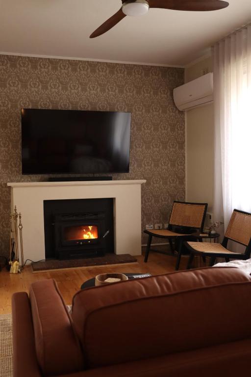 a living room with a couch and a fire place at Vale & Vine in McLaren Vale