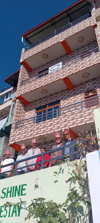 a group of people sitting on a balcony of a building at Sunshine homestay in Tānsen