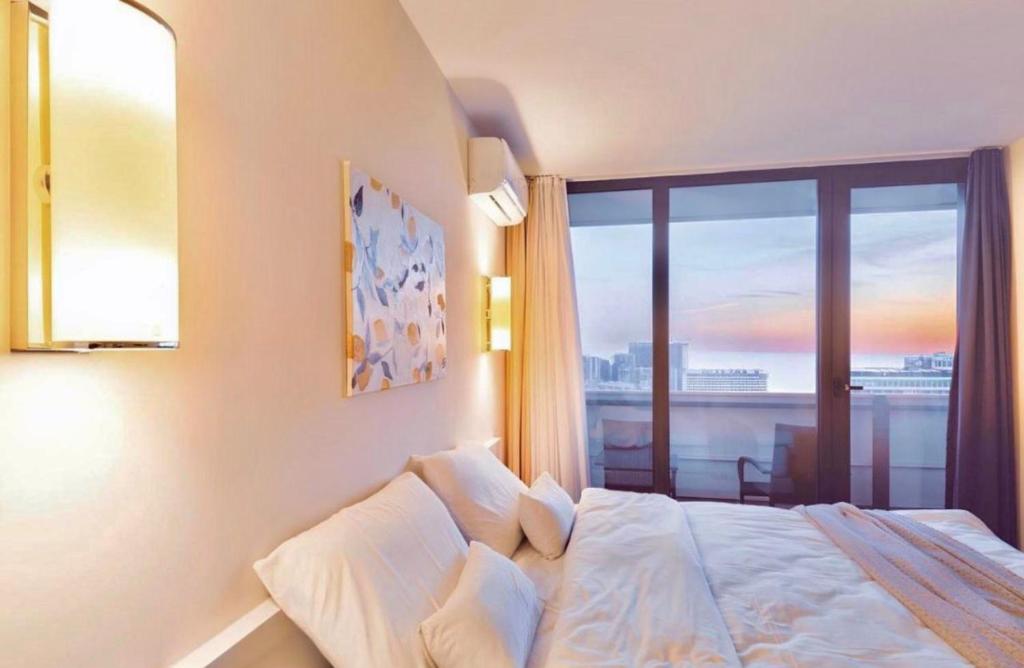 a bedroom with a large bed with a large window at Orbi City Amazing Apartments in Batumi