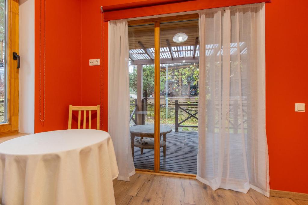 a room with orange walls and a table and a window at Gauja forest retreat in Gauja
