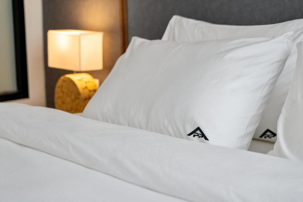 a close up of two beds with white sheets and pillows at Wyndham Gardens 1321 Studio 1m from Naithon Beach in Nai Thon Beach