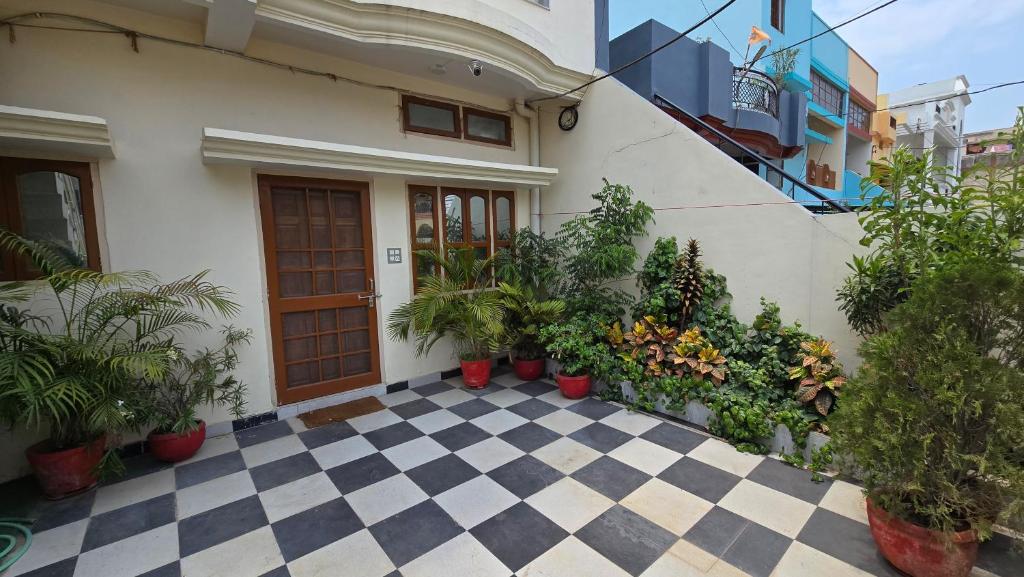a house with potted plants on a checkered floor at Aditi Premium Homestay GF in Jabalpur