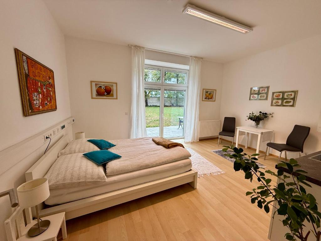 a bedroom with a bed and a large window at Giardino Airport Apartment with garden in Schwechat