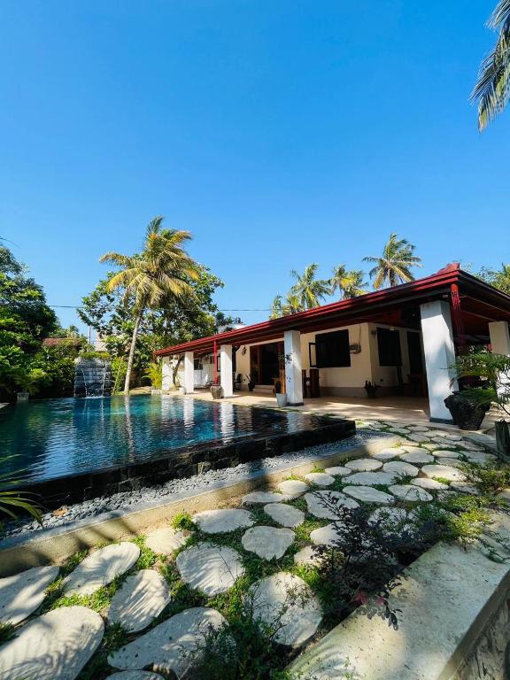 a house with a swimming pool next to a building at Villa Climax in Ahangama