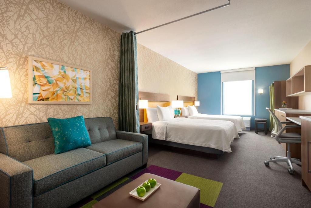 a hotel room with a bed and a couch at Home2 Suites By Hilton Memphis Downtown in Memphis