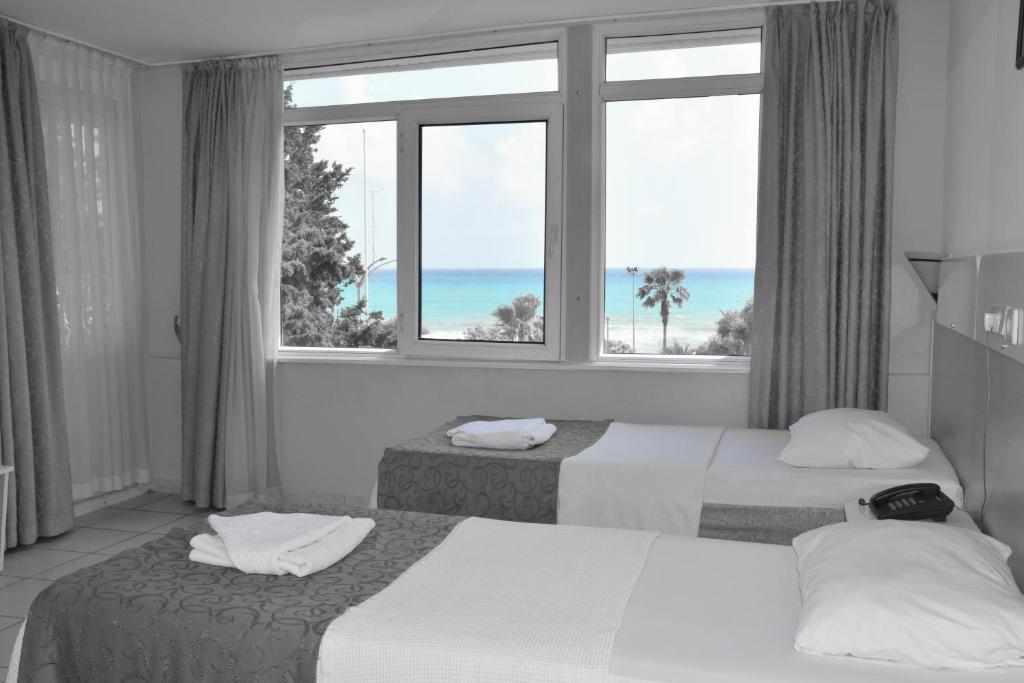 Una habitación de hotel con dos camas y una ventana. en Resitalya Hotel, en Alanya