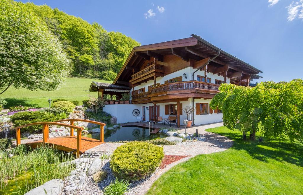 a house with a bridge in front of a yard at BERGSUCHT-Ruhpolding in Ruhpolding