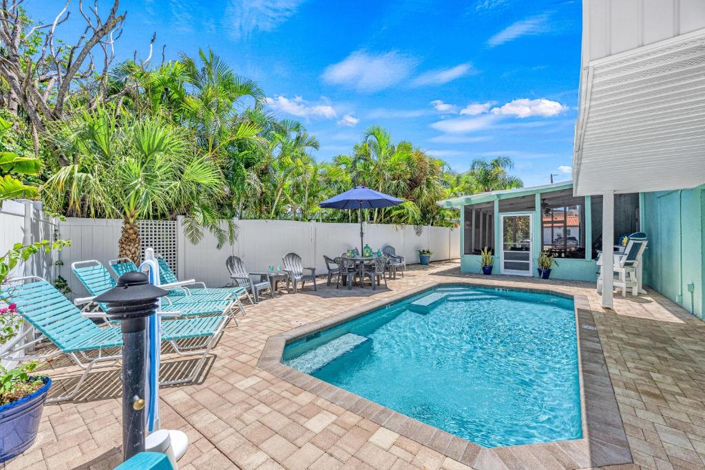 a patio with a swimming pool and chairs and a table at Plumbago - 5251C in Siesta Key