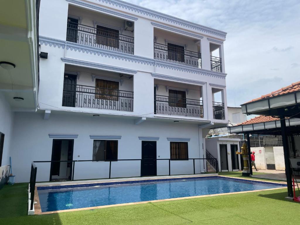 a white building with a swimming pool in front of it at Angkor Sunshine Oasis in Siem Reap