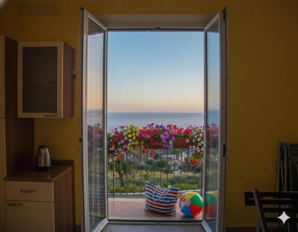 a sliding glass door with a view of the ocean at Casa Conca Azzurra in Costarainera