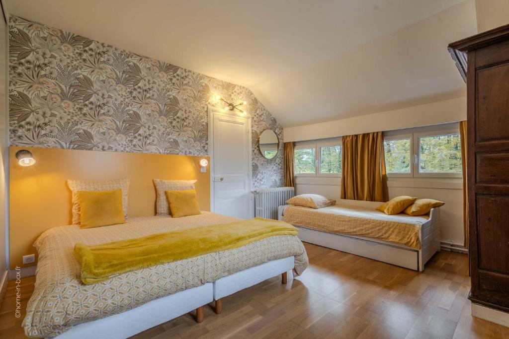 1 Schlafzimmer mit 2 Betten und gelben Kissen in der Unterkunft La meulière de Guerlande - Disney 20min in Lumigny