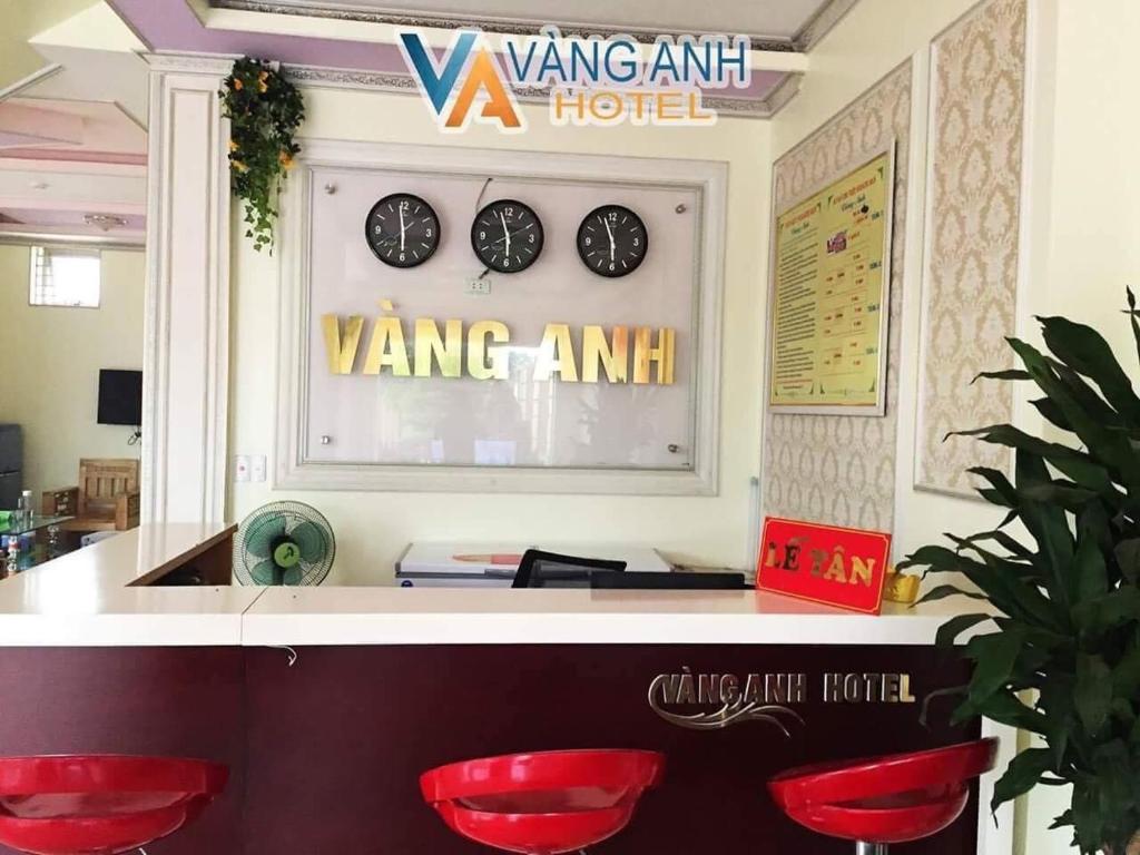 a room with two clocks on the wall and red chairs at Khách sạn Vàng Anh in Kiên Giáp Ha