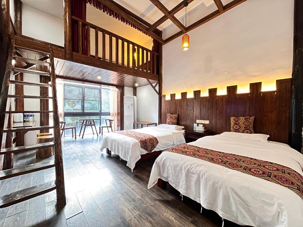 um quarto com 2 camas e uma sala de jantar em 张家界畔山驿栈 em Zhangjiajie