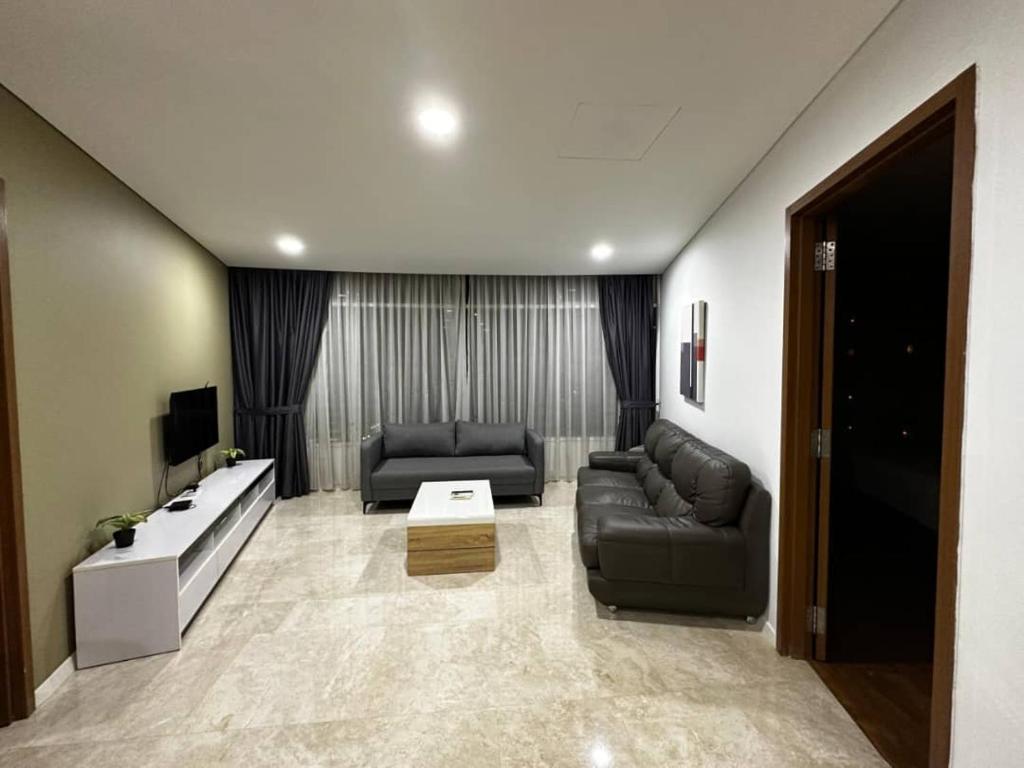 a living room with two couches and a tv at Vortex suites klcc by Kualalampur vibes in Kuala Lumpur