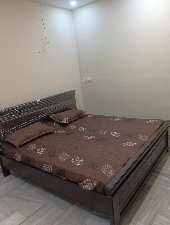 a bed in a room with a bed frame at Msquare guest room in Godāvari