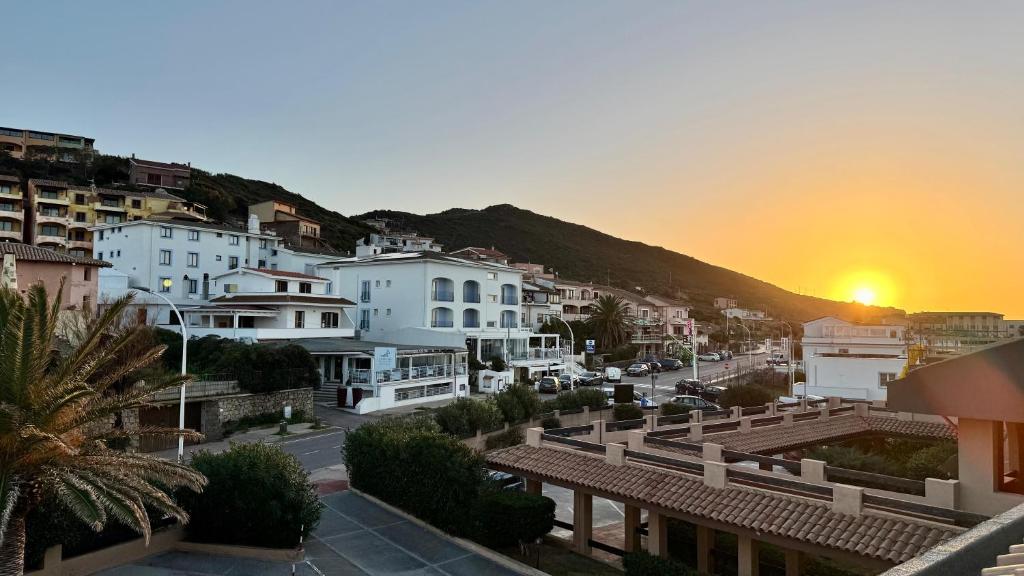 a view of a city with the sunset in the background at Appartamento Quadrifoglio in Castelsardo