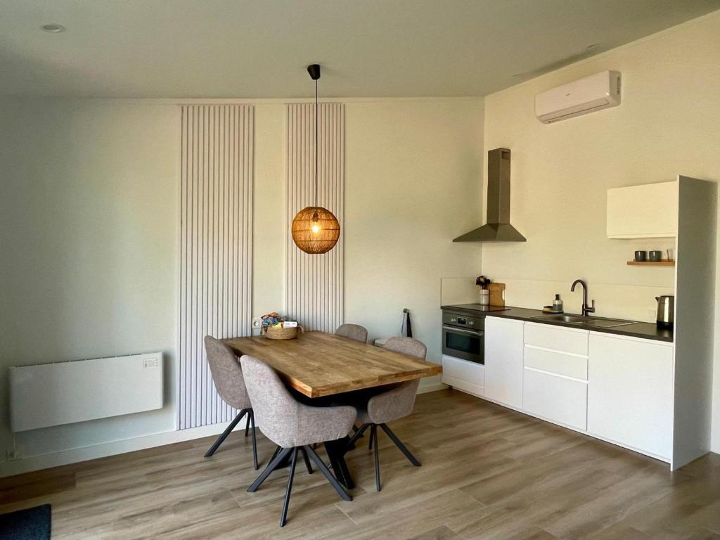 WestdorpeにあるFarmhouse Bintje met Aircoのキッチン(木製テーブル、いくつかの椅子付)